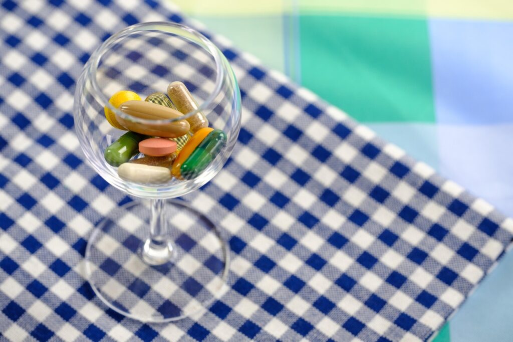 Gélules à base de champignons adaptogènes dans un verre posé sur une table.