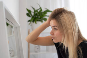 Gros plan femme perdant ses cheveux regardant dans le miroir